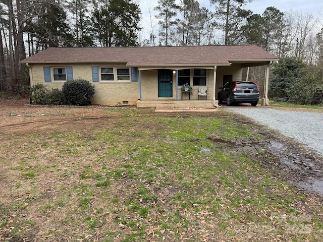 ranch-style home featuring a front lawn, covered porch, and a carport