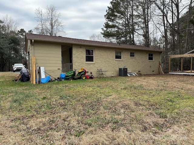 back of house featuring central air condition unit and a yard