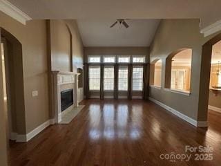 unfurnished living room featuring ornamental molding, dark hardwood / wood-style flooring, and lofted ceiling