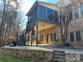 rear view of house featuring ceiling fan and a patio