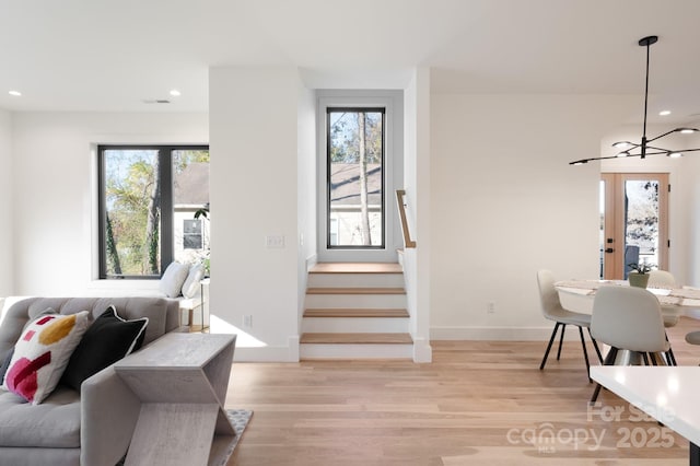 living room featuring light hardwood / wood-style floors, a chandelier, and plenty of natural light