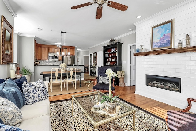 living room with ornamental molding, ceiling fan, hardwood / wood-style floors, and sink