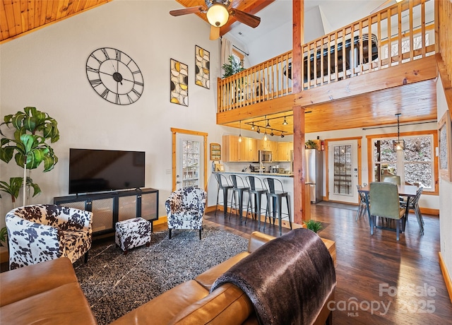 living room with ceiling fan, high vaulted ceiling, track lighting, dark hardwood / wood-style flooring, and wooden ceiling