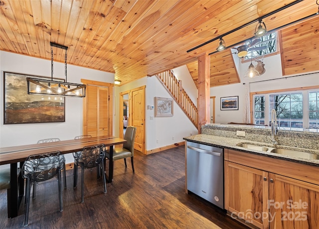 kitchen featuring dishwasher, sink, hanging light fixtures, and dark stone countertops