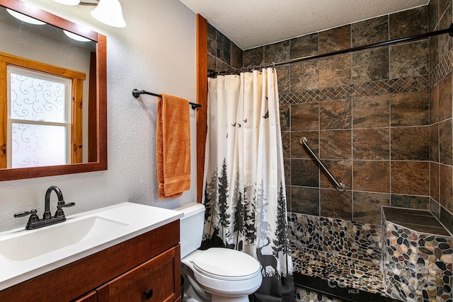 bathroom featuring vanity, toilet, curtained shower, and a textured ceiling