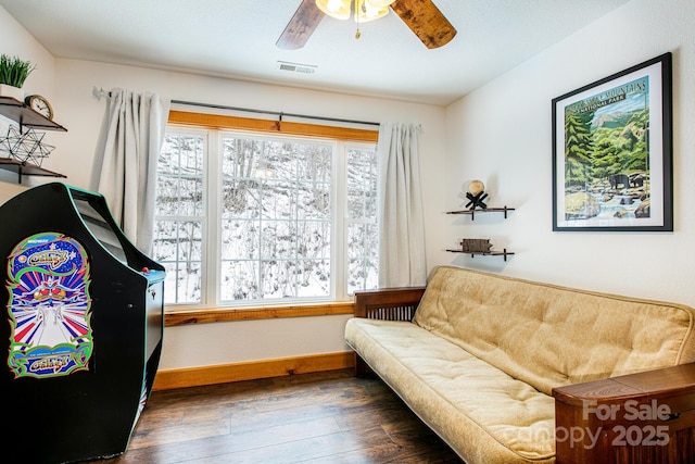 living area featuring dark hardwood / wood-style flooring and ceiling fan