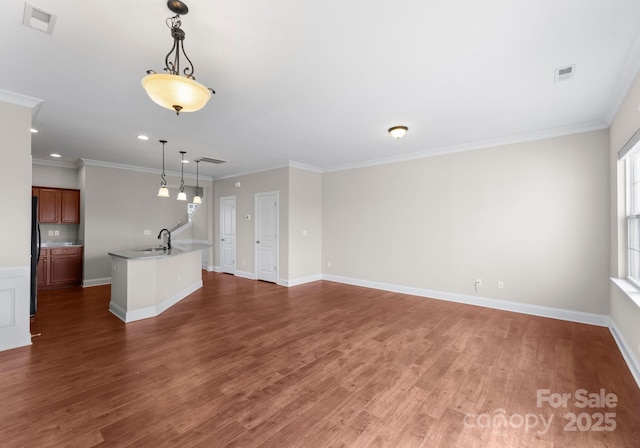 unfurnished living room featuring sink, crown molding, and dark hardwood / wood-style flooring