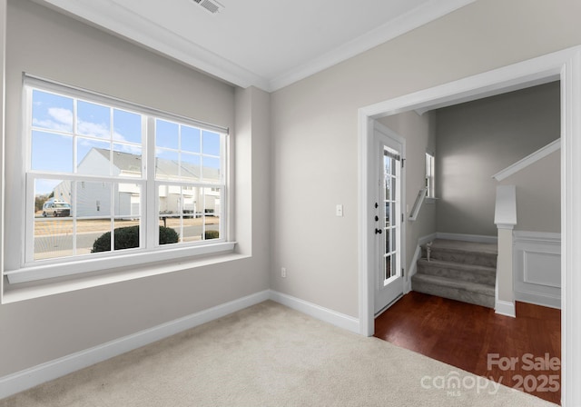 entryway with dark carpet and ornamental molding