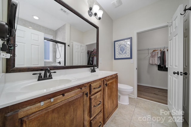 bathroom featuring toilet, vanity, an enclosed shower, and tile patterned flooring