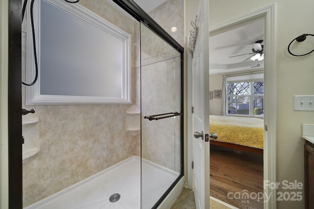 bathroom featuring ceiling fan, vanity, and a shower