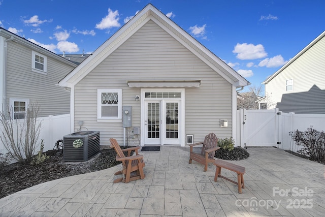 rear view of property with cooling unit and a patio area