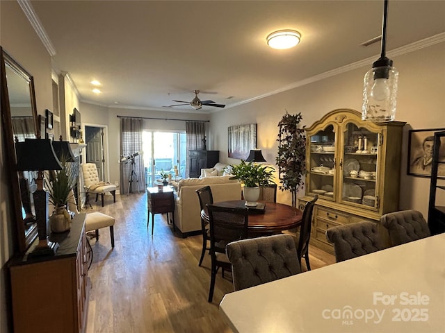 dining space featuring ceiling fan, wood-type flooring, and ornamental molding