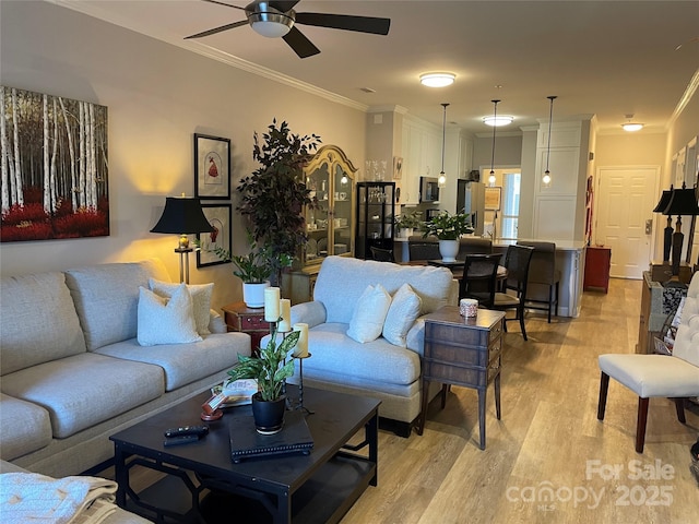 living room featuring ceiling fan, light wood-type flooring, and ornamental molding