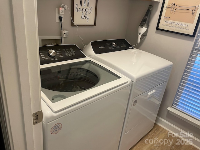 laundry area featuring washing machine and dryer and hardwood / wood-style flooring