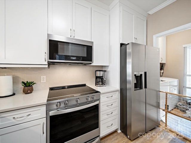 kitchen featuring white cabinets, washer and dryer, stainless steel appliances, and light countertops