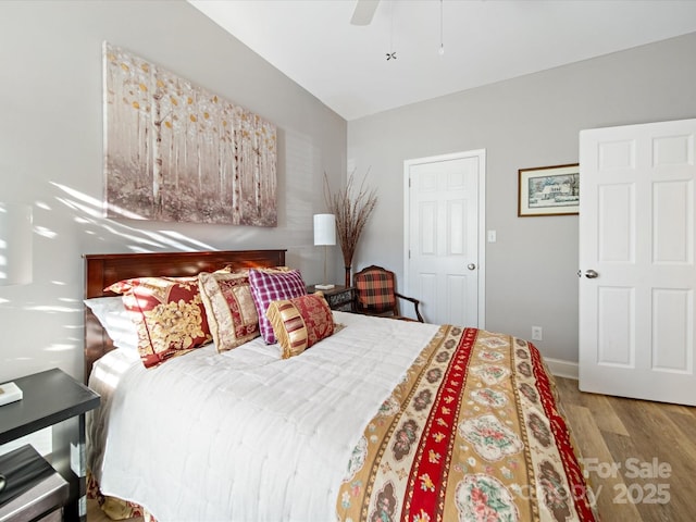 bedroom with vaulted ceiling, ceiling fan, and wood finished floors