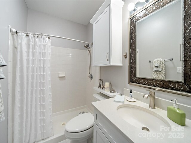 full bath with a stall shower, vanity, and toilet