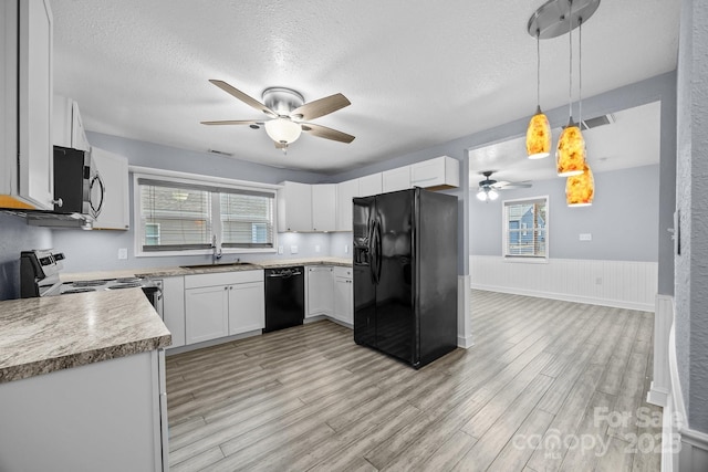 kitchen with pendant lighting, black appliances, white cabinets, sink, and a textured ceiling