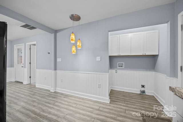 washroom with hookup for an electric dryer, light hardwood / wood-style floors, cabinets, and hookup for a washing machine