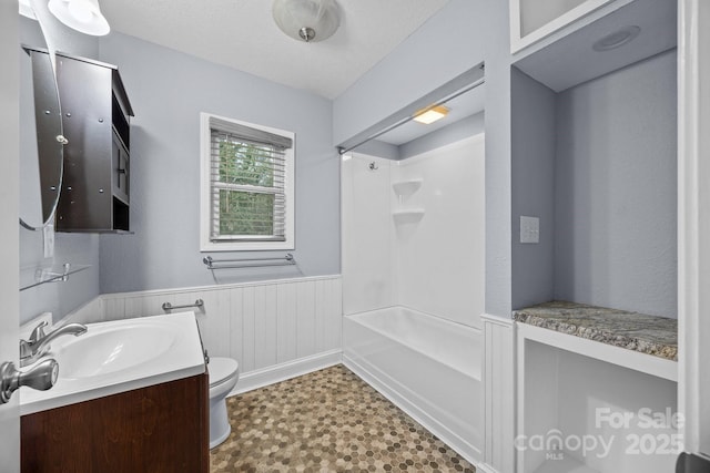 full bathroom featuring washtub / shower combination, vanity, and toilet