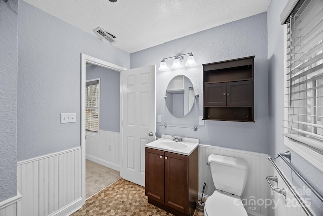 bathroom featuring vanity, toilet, and a textured ceiling