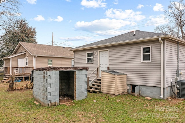 back of property featuring a deck, cooling unit, and a lawn