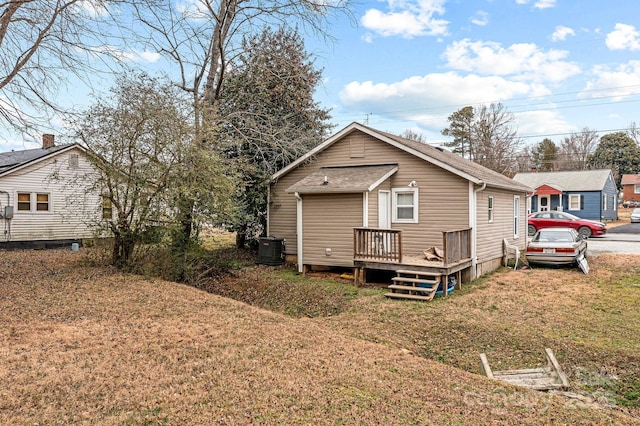 rear view of house featuring a lawn and cooling unit