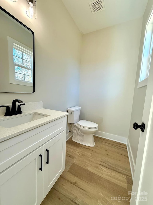 bathroom with vanity, toilet, and wood-type flooring