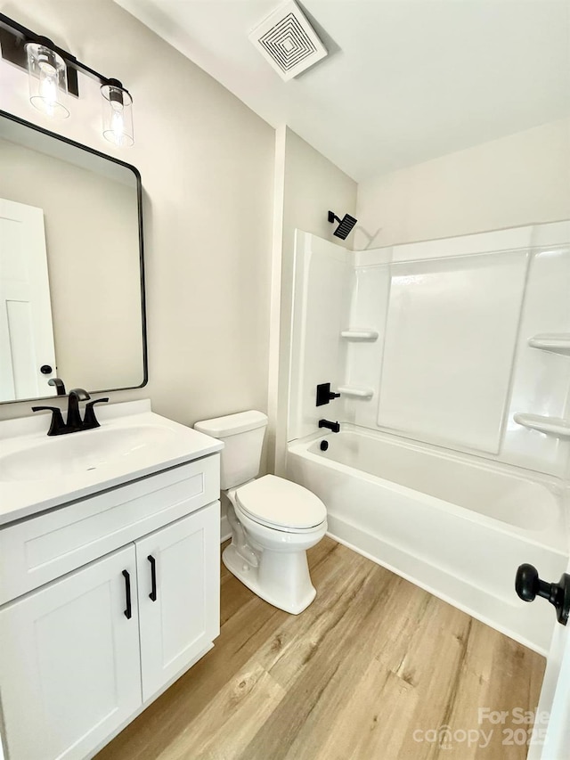 full bathroom with vanity, wood-type flooring, bathtub / shower combination, and toilet