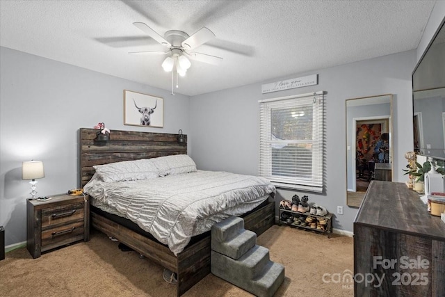 bedroom with ceiling fan, light colored carpet, and a textured ceiling