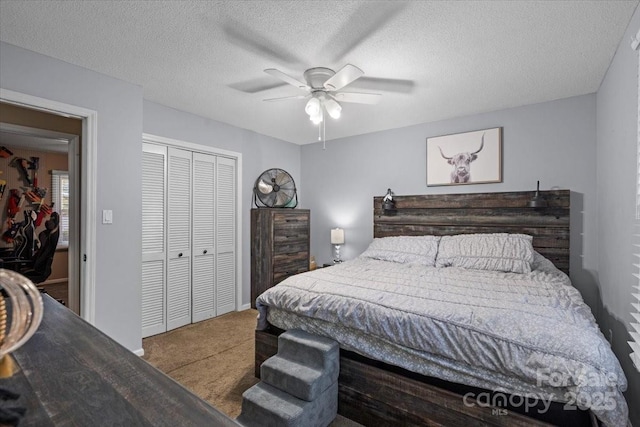 bedroom with carpet flooring, a textured ceiling, ceiling fan, and a closet