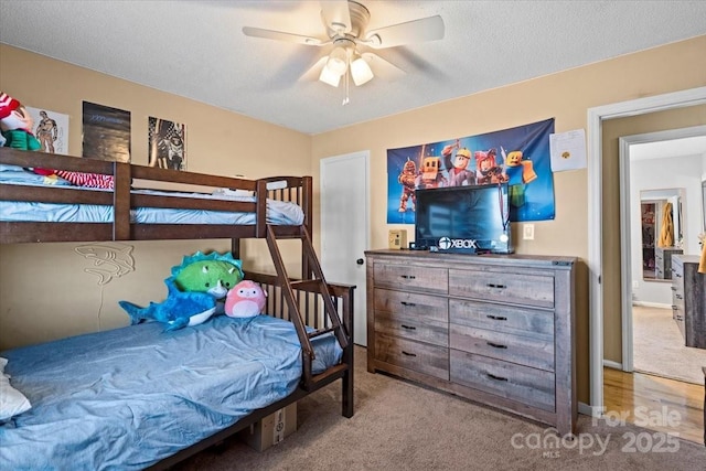 bedroom with carpet floors, ceiling fan, and a textured ceiling