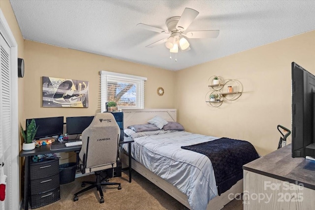 bedroom with ceiling fan, carpet floors, and a textured ceiling