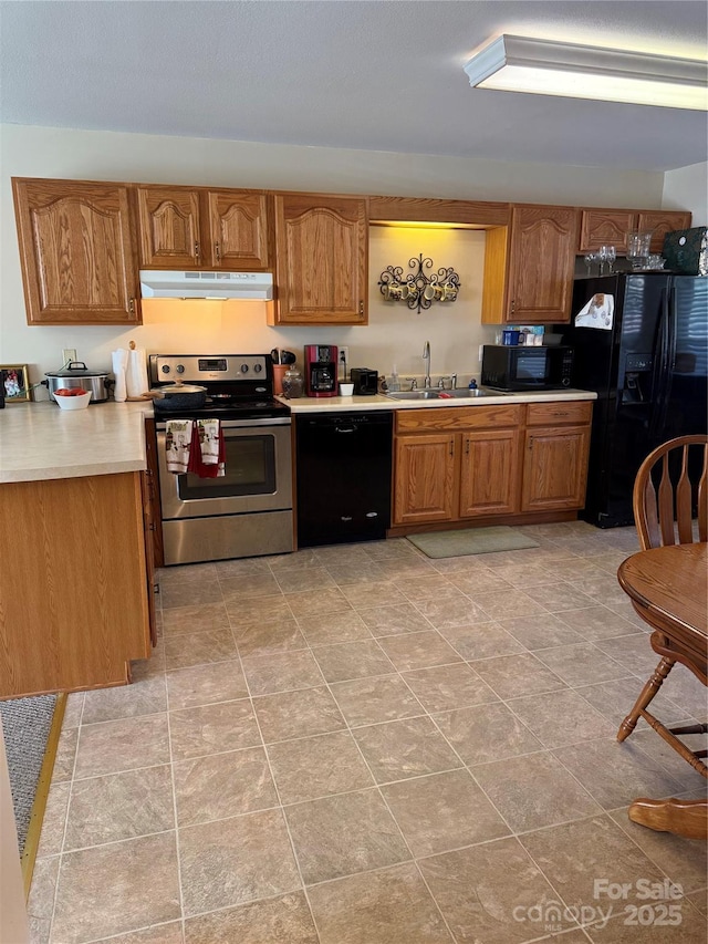 kitchen featuring black appliances, light tile patterned floors, and sink