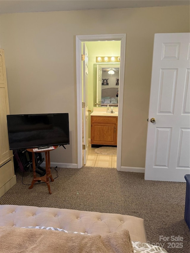 carpeted bedroom with connected bathroom and sink