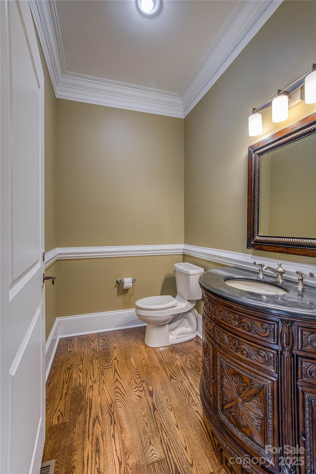 bathroom featuring ornamental molding, vanity, hardwood / wood-style flooring, and toilet