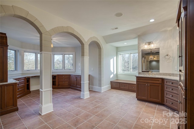 bathroom featuring tile patterned floors, a wealth of natural light, vanity, and decorative columns