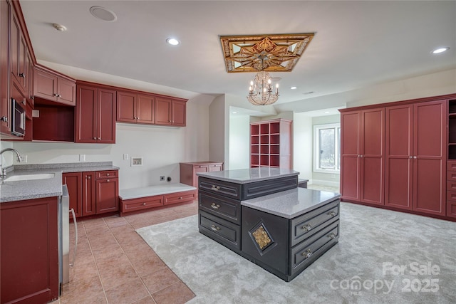 kitchen featuring sink, a center island, a chandelier, and light stone countertops