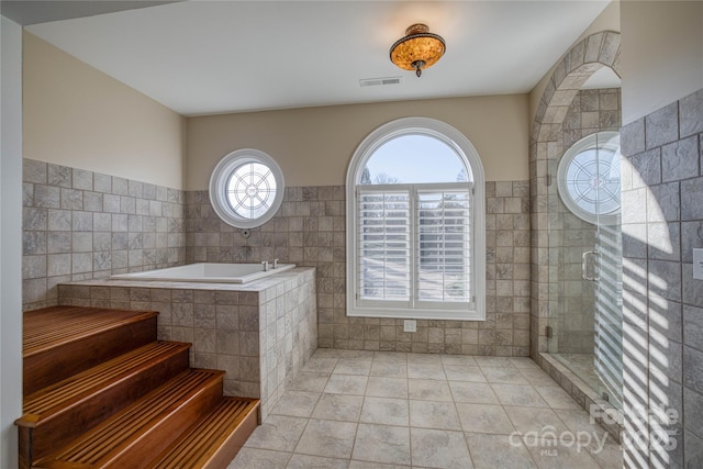 bathroom featuring tile patterned floors, tile walls, and plus walk in shower