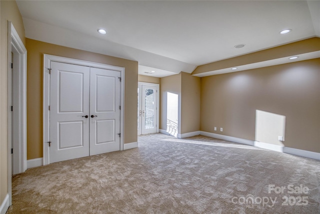 interior space with light colored carpet and lofted ceiling