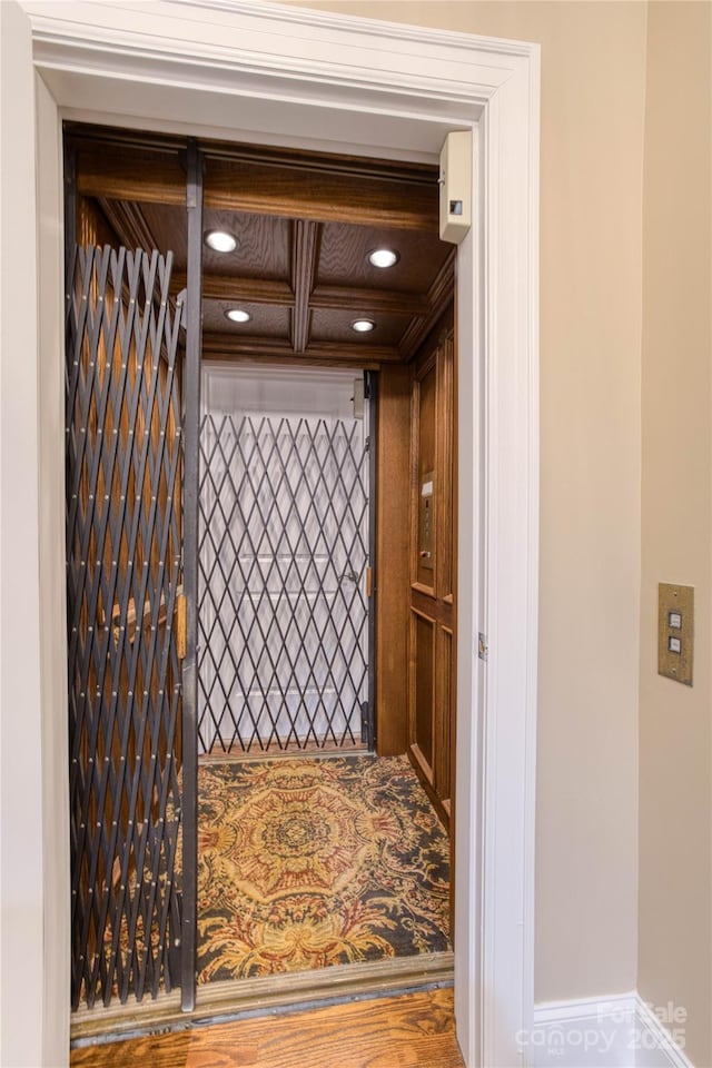 interior space featuring coffered ceiling and hardwood / wood-style floors