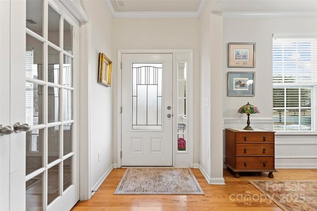 entrance foyer featuring crown molding and light hardwood / wood-style flooring