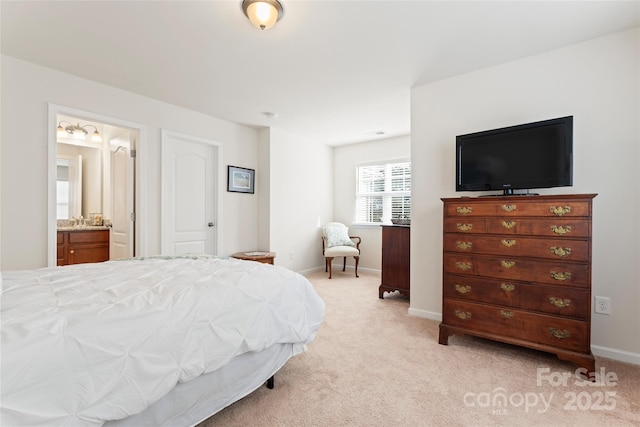 bedroom with ensuite bath and light colored carpet