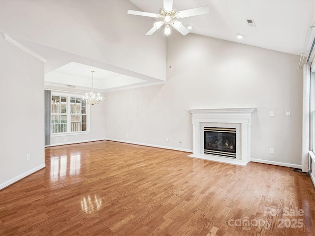 unfurnished living room featuring ceiling fan with notable chandelier and light hardwood / wood-style floors