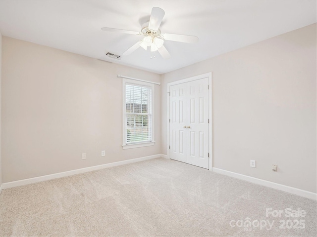 carpeted spare room featuring ceiling fan