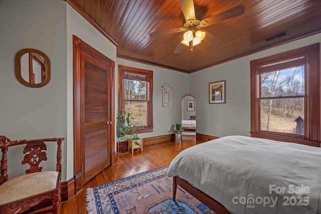 bedroom featuring hardwood / wood-style flooring, ceiling fan, wood ceiling, and ornamental molding