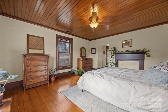 bedroom featuring hardwood / wood-style flooring, crown molding, wooden ceiling, and ceiling fan