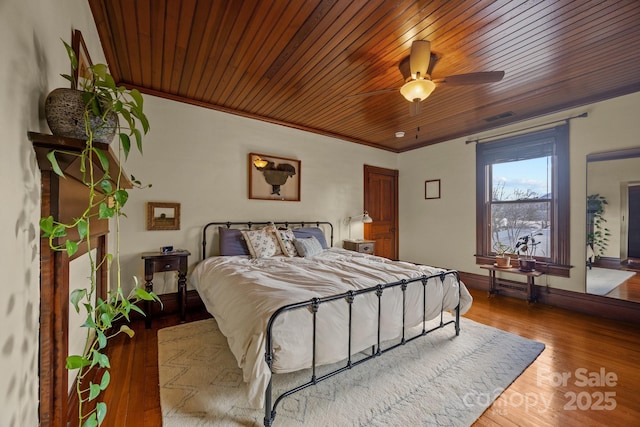 bedroom featuring crown molding, light wood-type flooring, wooden ceiling, and ceiling fan