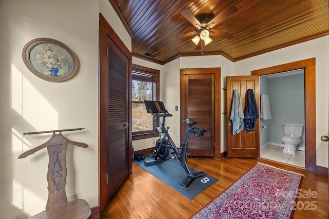 workout area featuring crown molding, wood ceiling, and light hardwood / wood-style flooring