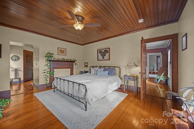 bedroom with wood ceiling, ceiling fan, ornamental molding, and light wood-type flooring